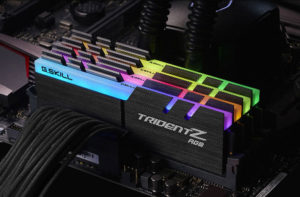 The image shows a set of rainbow lighted ram sticks sitting on top of a motherboard.