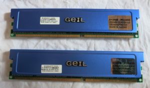 The image shows two sticks of DDR5 RAM sitting on top of a white surface. The RAM sticks are black and have a silver heat spreader on top. The heat spreader has the GEIL logo on it.